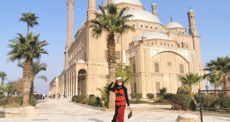 Un touriste posant devant l'impressionnante Mosquée Mohammad Ali au sein de la Citadelle du Caire.