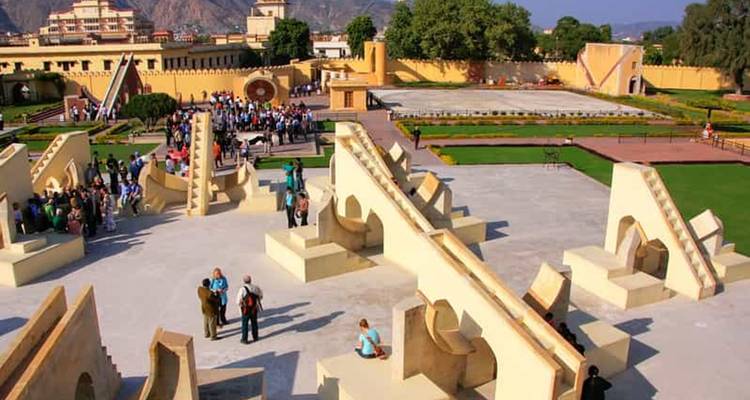 Bezoekers verkennen de architectonische instrumenten van Jaipur's Jantar Mantar-observatorium op een zonnige dag.