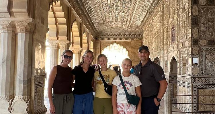 Familie groep lachend in de sierlijke Sheesh Mahal gang met ingewikkeld spiegelwerk