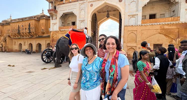 Reizigers die poseren met een versierde olifant in de drukke ingangsplaats van het Amber Fort