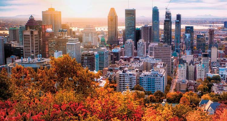 Skyline von Montreal im Herbst, fotografiert vom Aussichtspunkt Mount Royal mit farbenfrohem Laub im Vordergrund