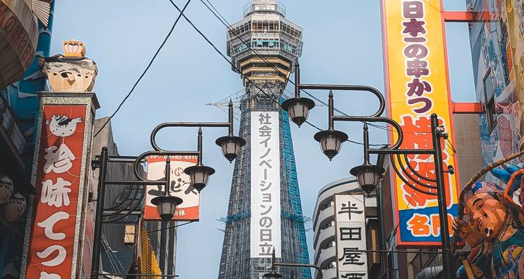 Les enseignes au néon colorées et la tour Tsutenkaku s'élevant au-dessus du quartier animé de Shinsekai à Osaka