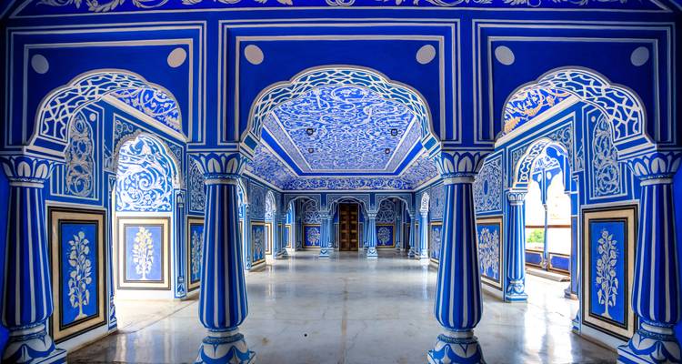 Das lebendige kobaltblaue Interieur des City Palace in Jaipur zeichnet sich durch aufwendige weiße Blumenmuster, Bögen und Säulen aus.