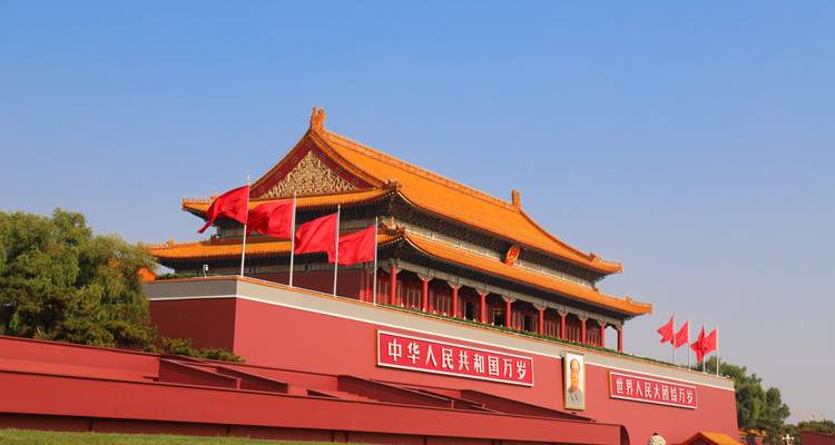 Tiananmenpoort versierd met rode vlaggen onder een strakblauwe Beijing-lucht.