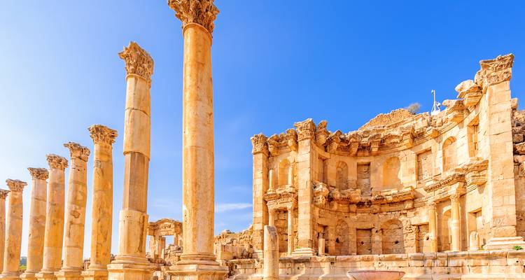 Les colonnes romaines et les ruines baignées de soleil contre un ciel bleu dégagé à Jérash.