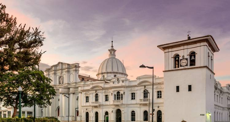 Los elegantes edificios coloniales de Popayán brillan bajo un cielo al atardecer de colores pastel.