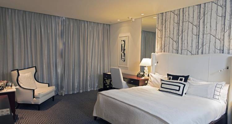 Chambre d'hôtel moderne avec décoration blanche et tapis à motifs