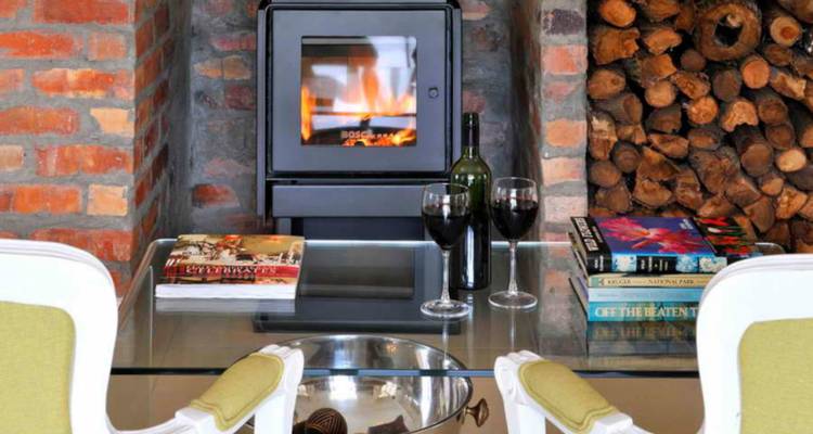 Foyer intérieur douillet avec du vin et des livres disposés sur une table basse en verre