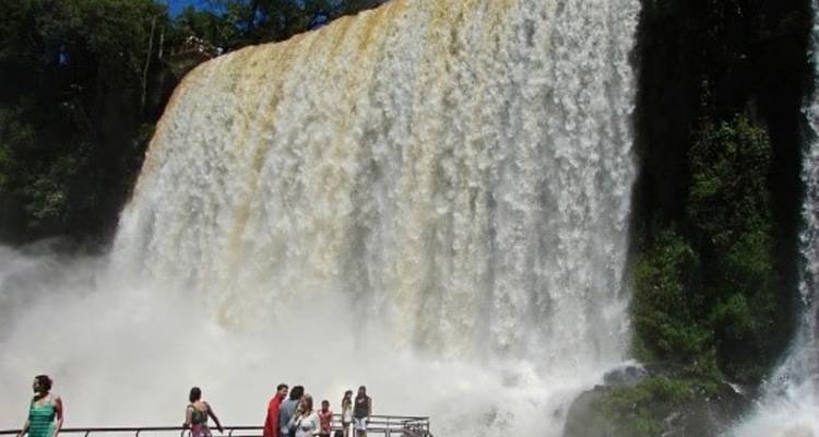 Des visiteurs sur une plateforme dominée par un mur imposant des chutes d'Iguazu