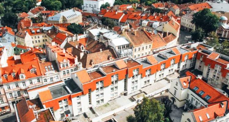 Une vue aérienne panoramique de la Vieille Ville de Vilnius avec ses toits en tuiles rouges et ses rues historiques étroites.