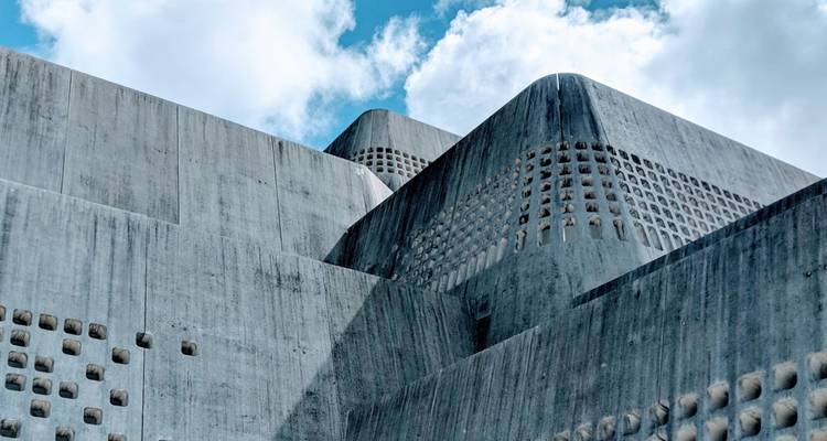 Abstrakter Blickwinkel moderner Betonarchitektur mit geometrischen Mustern vor hellem Himmel