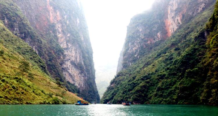Smalle turquoise rivier die door imposante kalksteenrotsen omgeven door mist snijdt