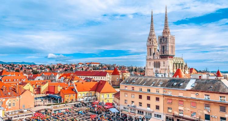 Les toits colorés et les flèches de la cathédrale de Zagreb sous un ciel bleu éclatant