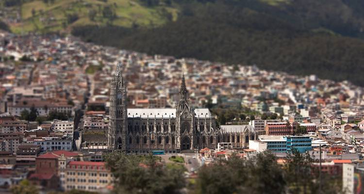 Vista miniaturizada de la Basilica del Voto Nacional dominando el denso paisaje urbano de Quito