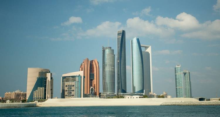 Horizonte moderno de Abu Dabi con las Torres Etihad y otros rascacielos vistos a través de las aguas turquesas del Golfo.