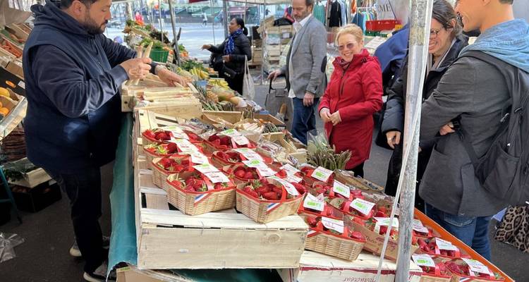 Le vendeur vend des paniers de fraises fraîches au marché extérieur animé.