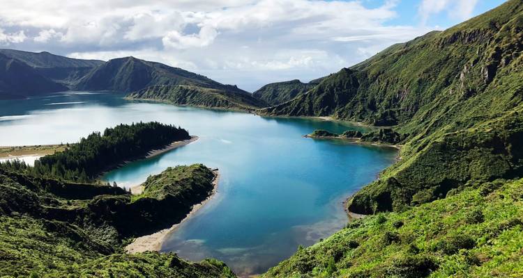 Lac de cratère turquoise entouré de pentes émeraude escarpées et de crêtes volcaniques spectaculaires aux Açores.