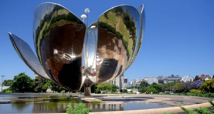 Glänzende Metallblütenblätter der Skulptur Floralis Genérica öffnen sich vor einem klaren blauen Himmel