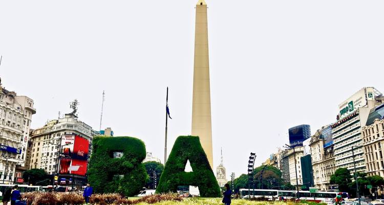 Das ikonische Buenos-Aires-Obelisk erhebt sich hinter Buchstabentopiarien BA an einem bewölkten Tag