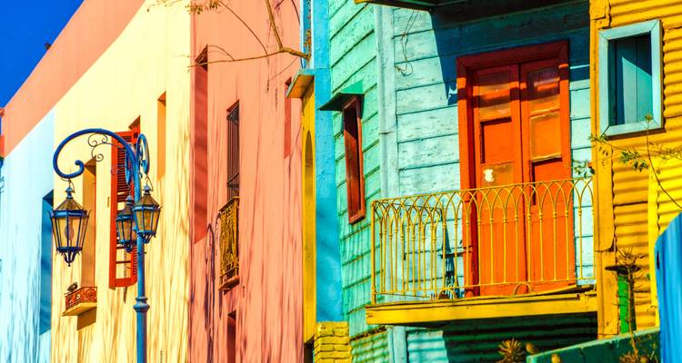 Hell angestrichene Fassaden und Balkone des Viertels La Boca unter klarem Himmel.