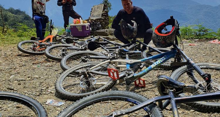 Mountainbikes op de grond terwijl rijders een pauze nemen op een grindweg uitzichtpunt
