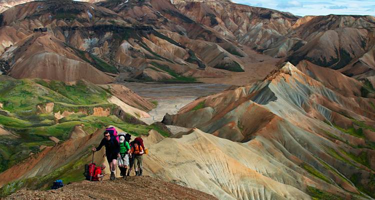 Backpackers wandelen langs een veelkleurige rhyoliet bergrug in het dramatische Landmannalaugar hoogland.