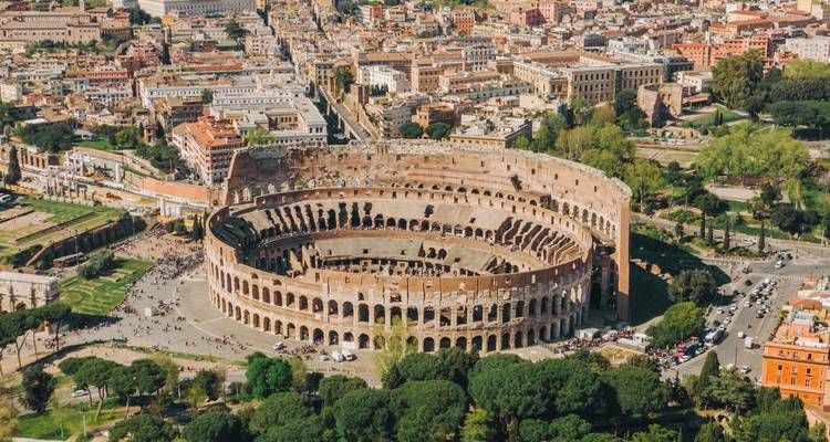 Luchtfoto van het Colosseum omringd door de historische structuur en groene parken van Rome.