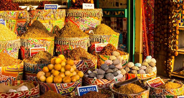 Des paniers colorés débordant d'épices, de citrons et d'herbes aromatiques brillent sous la lumière chaleureuse du marché.