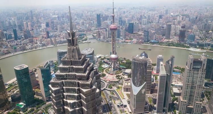 Luchtfoto van moderne wolkenkrabbers in Shanghais Pudong-wijk met de Oriental Pearl Tower naast de rivier de Huangpu.