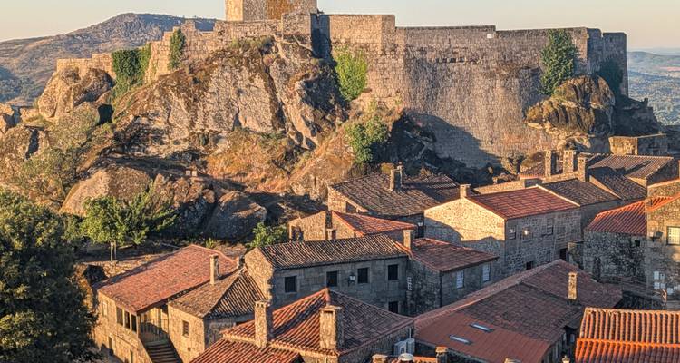 Castillo medieval en lo alto de la colina que se eleva sobre los tejados de Sortelha a la hora dorada