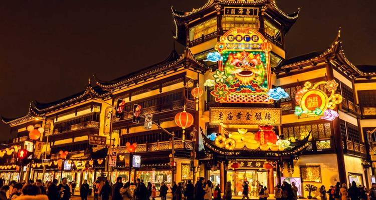 Lebendige, laternenbeleuchtete alte Straße in Shanghai, gefüllt mit abendlichen Einkäufern und Gästen.