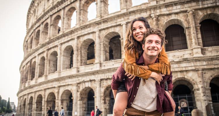 Gelukkig stel in piggyback-positie voor de oude bogen van het Colosseum.