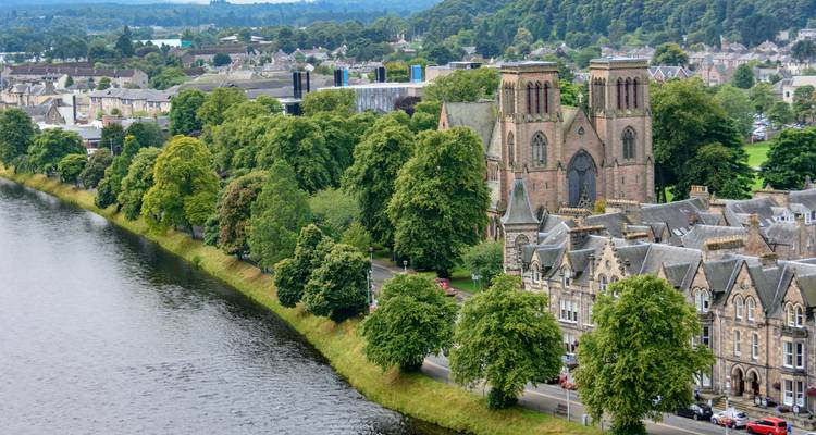 Vista aérea sobre el río Ness hacia la Catedral de Inverness con sus torres gemelas y sus calles arboladas
