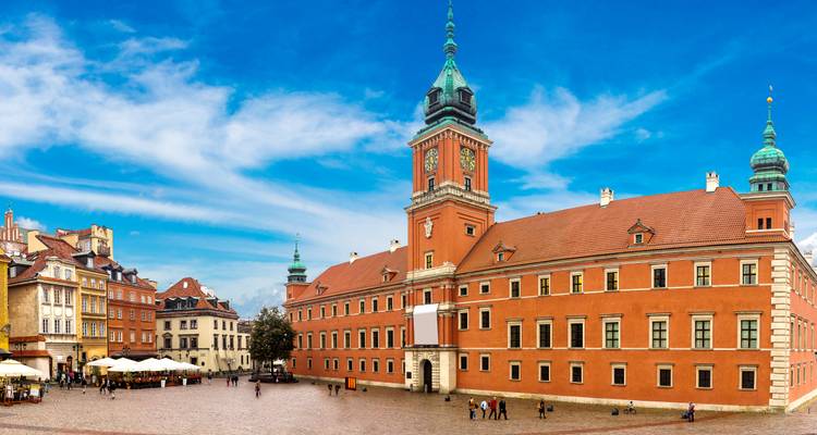 Toma panorámica del Castillo Real de Varsovia con un cielo azul despejado encima.