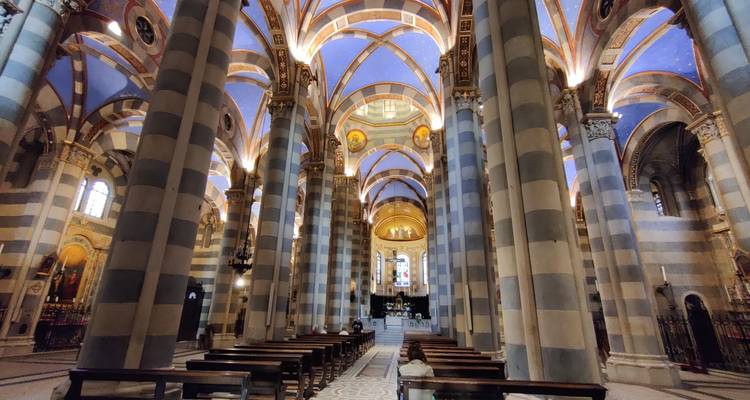 Intérieur de cathédrale orné avec des colonnes en marbre rayé et un plafond voûté bleu et or.