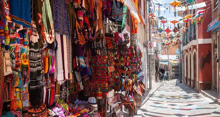 Un marché dans une ruelle animée déborde de textiles tissés colorés, de chapeaux et de souvenirs à La Paz.