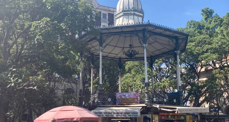 Viktorianischer eiserner Gazebo-Kiosk, umgeben von Bäumen und kleinen Marktständen an einem sonnigen Tag