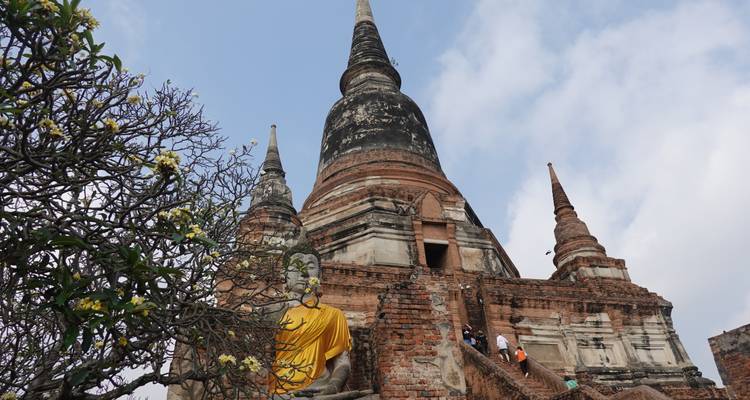 Vista hacia arriba de un gran chedi con obra de ladrillo y estatuas de Buda en Wat Yai Chai Mongkhon.