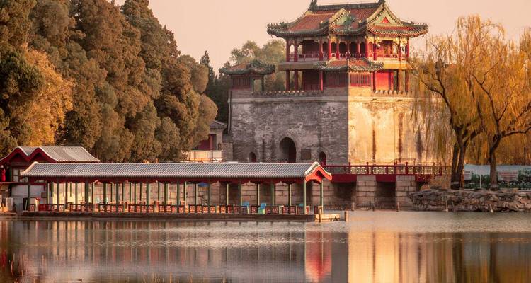 Goldenes Licht badet die Pavillons am Seeufer und Weidenbäume im Sommerpalast von Peking