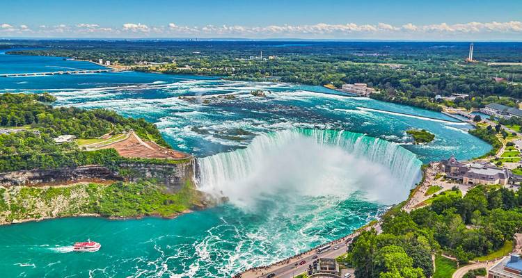 Luftaufnahme der Horseshoe Falls in Niagara Falls mit türkisblauem Wasser, das über die Klippe stürzt, und Nebel, der in die Luft aufsteigt