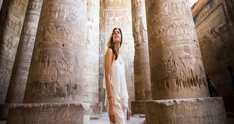 Frau erkundet eine antike Halle mit hieroglyphischen Steinpfeilern