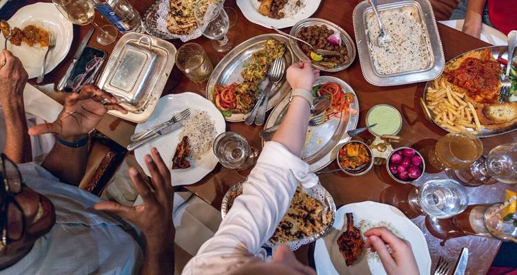 Vue aérienne d'un repas indien partagé avec des convives se servant dans différents plats.