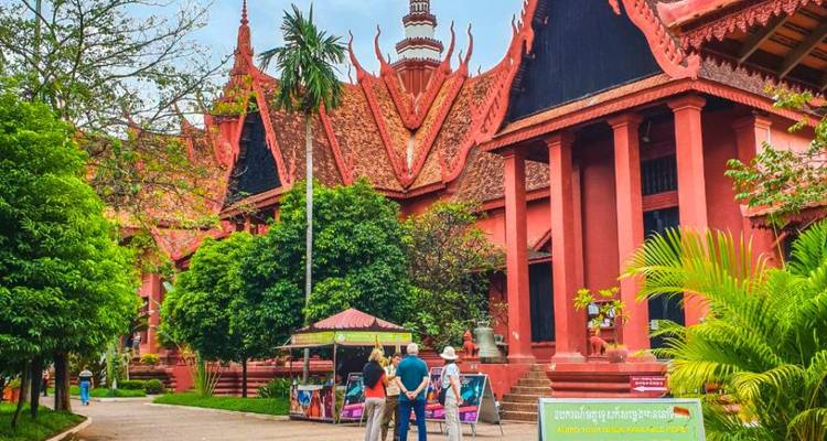 Los visitantes se detienen fuera del Museo Nacional de Camboya rodeado de exuberantes jardines y la arquitectura roja jemer.