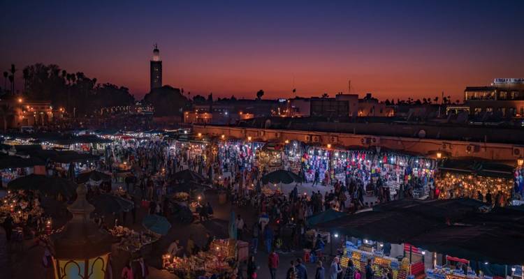 Vue nocturne du souk de Marrakech illuminé sous un ciel bleu indigo profond