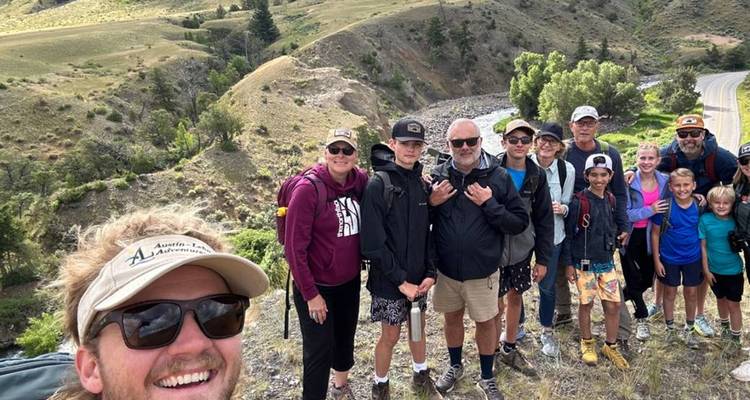 Grupo de senderismo guiado posando para una selfie en una cresta con vistas a los valles de Yellowstone