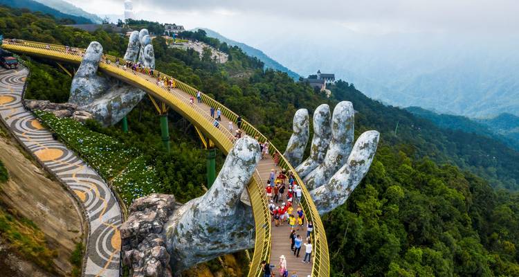 Ikonische Goldene Brücke, gestützt durch riesige Steinhände, die sich über üppige bewaldete Hügel erstrecken
