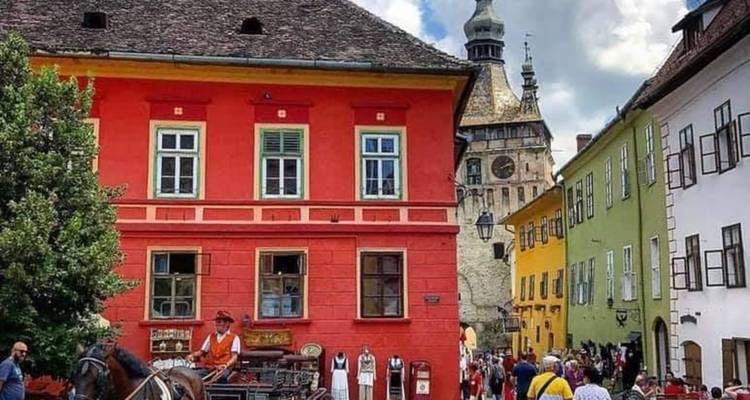 Calles vibrantes de Sighisoara con carruaje de caballos y casas multicolores que conducen a la torre del reloj