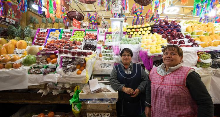 Étal de produits frais animé avec des vendeurs souriants dans un marché couvert