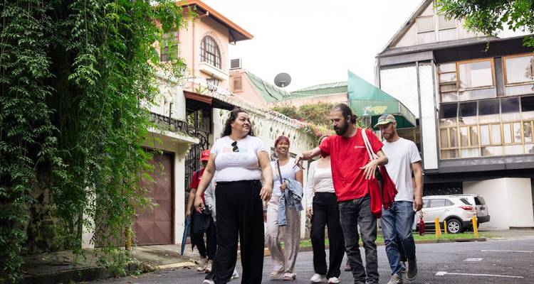 Les voyageurs se promènent le long d'une rue résidentielle bordée de verdure lors d'une visite pédestre urbaine.