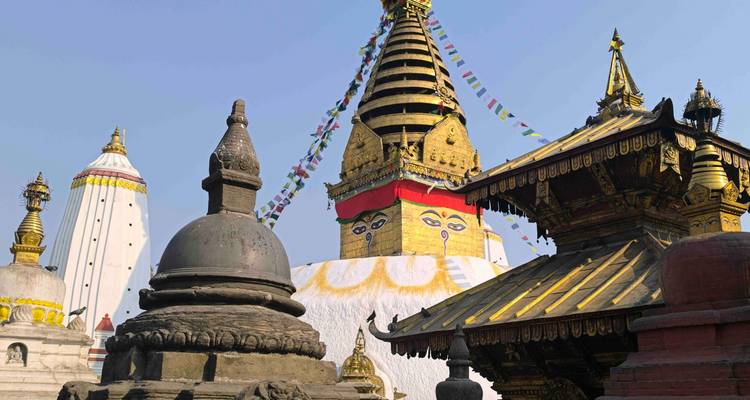 Colorida estupa Swayambhunath adornada con banderas de oración contra un cielo despejado